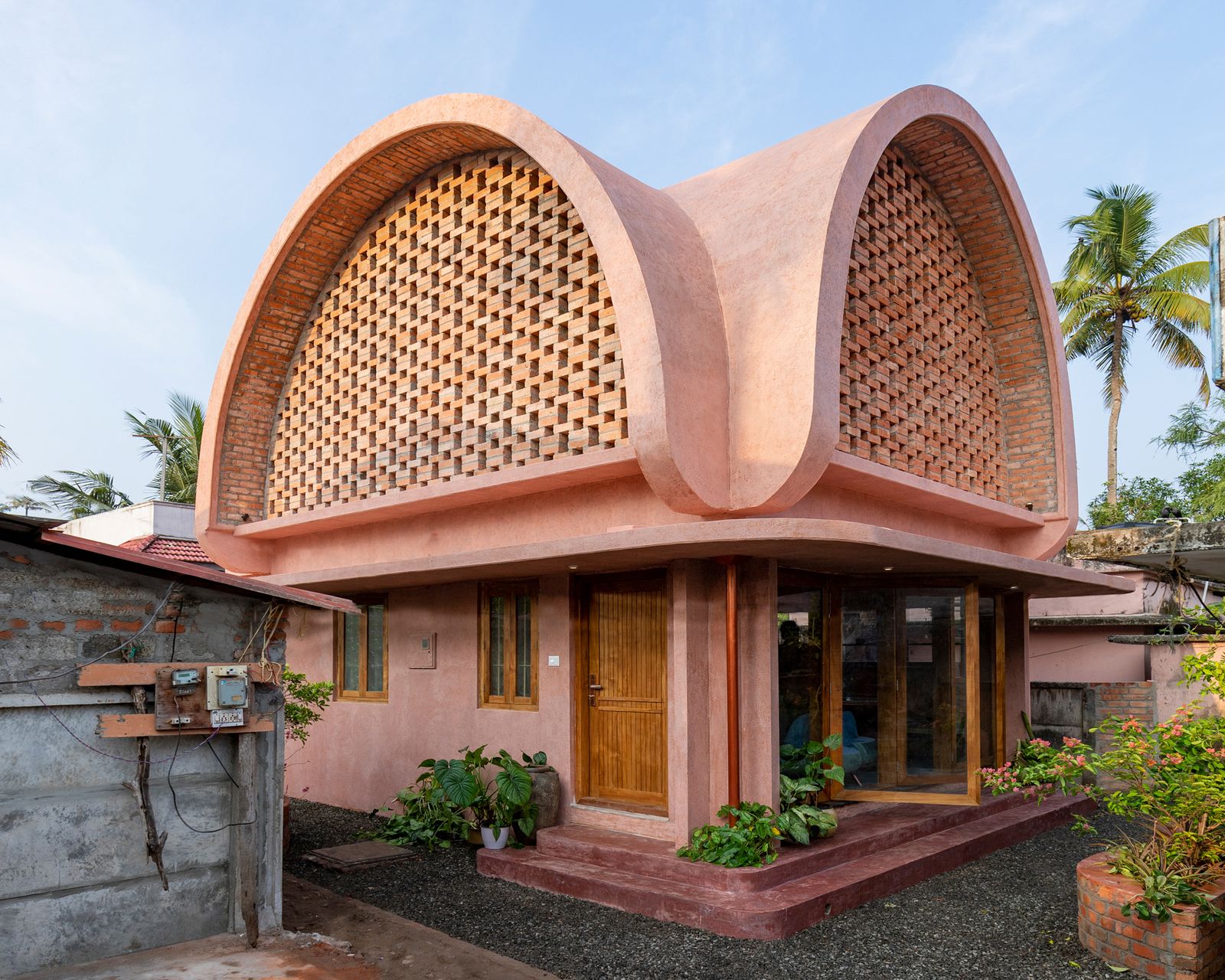 Working pro bono for a single mother and her two children, No Architects creates an experimental home with a vaulted roof, permeable walls, and custom furniture.